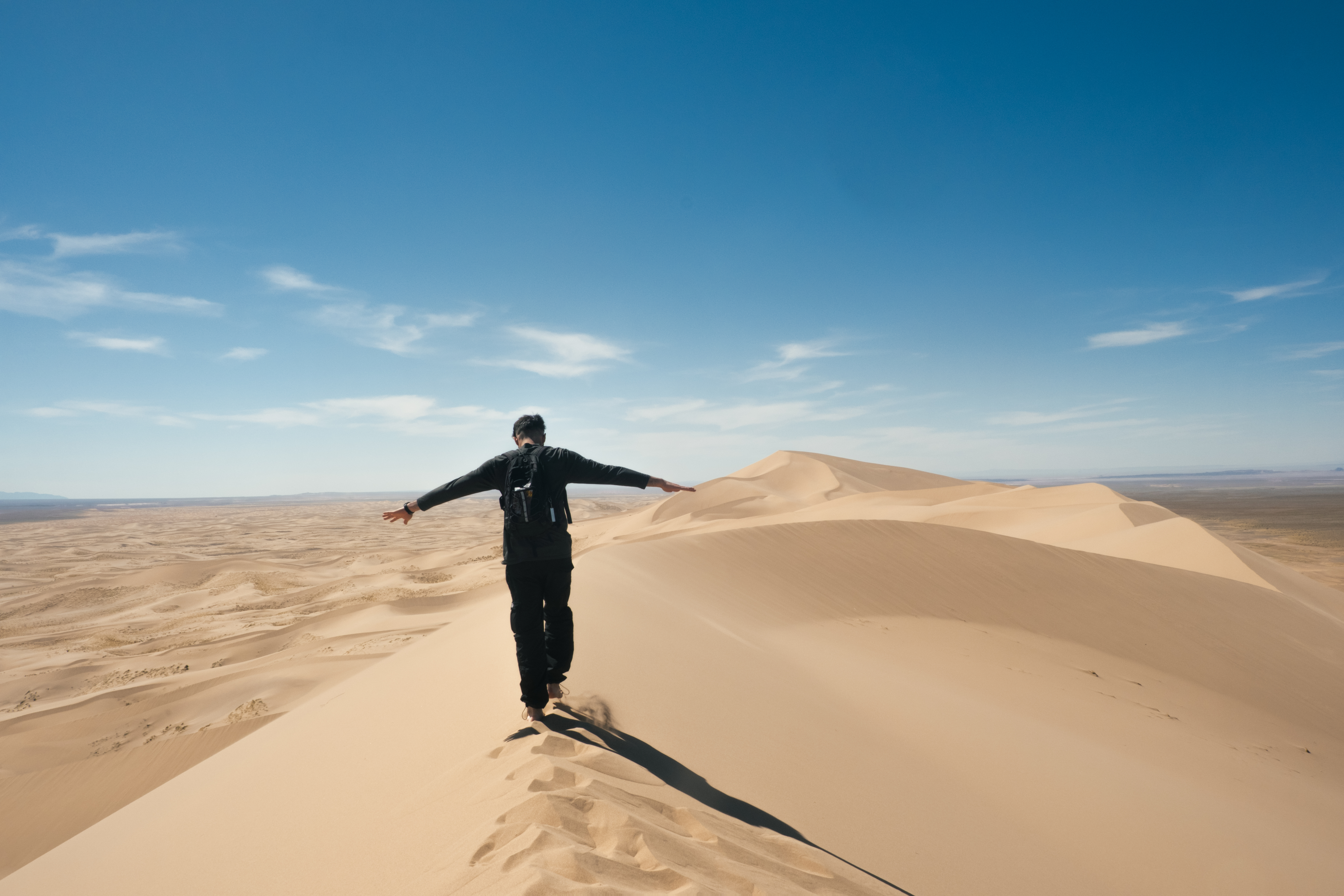 Una persona sulle dune della Mongolia sotto un cielo azzurro, fotografia di Pierpaolo Paluan