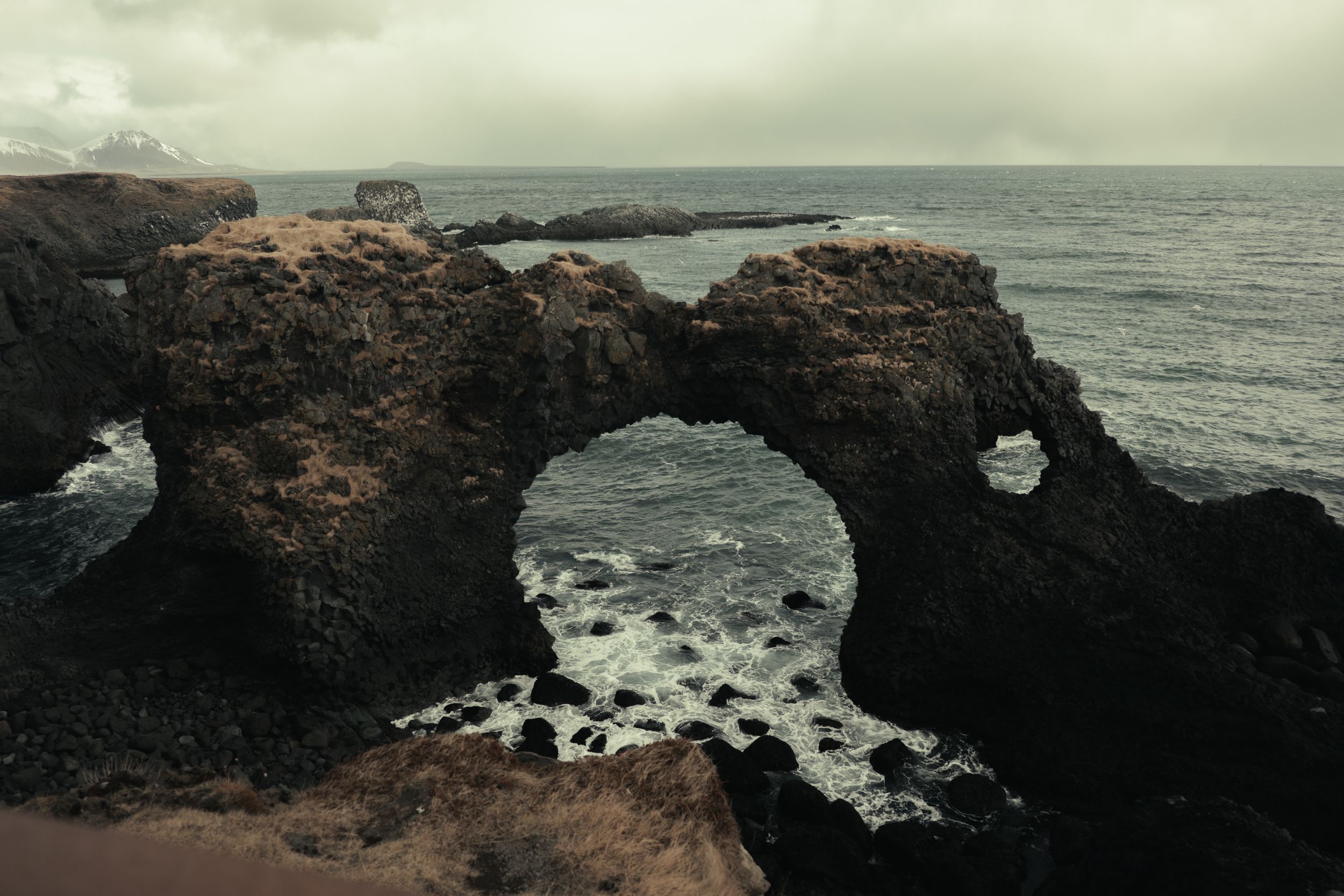 L’oceano e un arco di roccia basaltica sulla costa islandese, fotografia di Pierpaolo Paluan